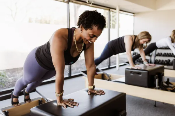 Women practicing Pilates on reformer machines.